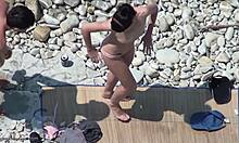Hottie topless cu părul negru își arată corpul pe o plajă