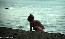 苗条的女孩在裸体海滩上展示她完全赤裸的身体