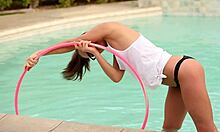 戴眼镜的马尾辫少女女友在游泳池里摆出呼啦圈