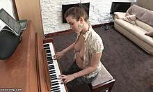 Lekfull brunett med pigga bröst spelar topless piano